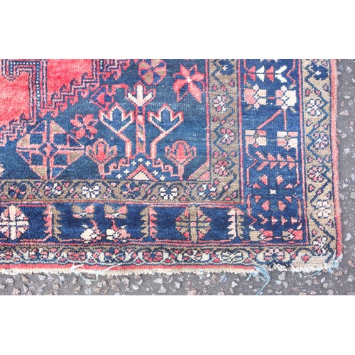 270 - Persian rug, the abrashed coral field with 3 linked latch-hook medallions, and indigo spandrels, wit... 