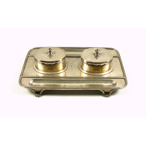 490 - George V silver ink stand of rounded rectangular form with 2 oval inkwells, the hinged covers enclos... 