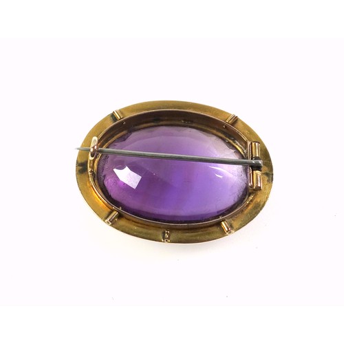 536 - A late Victorian gilt metal and amethyst faceted cabochon brooch, width 3.5cm, in a box. (2)