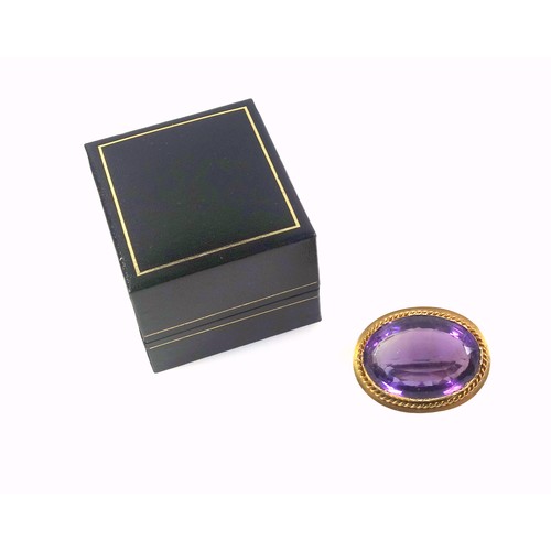 536 - A late Victorian gilt metal and amethyst faceted cabochon brooch, width 3.5cm, in a box. (2)