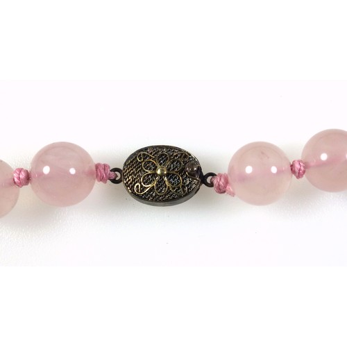 538 - A rose quartz necklace with a gilt white metal clasp stamped silver, length 62.5cm, the beads are 1.... 