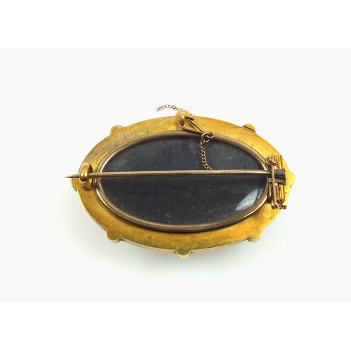 545 - Victorian gilt metal and black onyx mourning brooch, of oval form, the outer rim set seed pearls, en... 