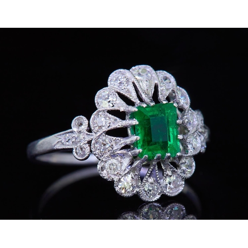 4 - EMERALD AND DIAMOND OPENWORK CLUSTER RING, set with a central emerald of approx. 0.63 ct. flanked wi... 