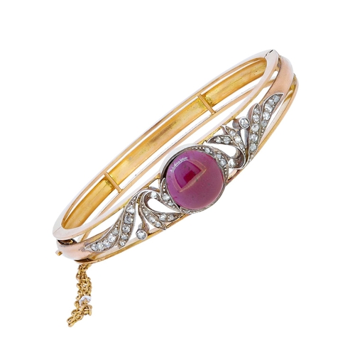 42 - ANTIQUE VICTORIAN GARNET AND DIAMOND BANGLE, set to the center of the top with a round cabochon cut ... 