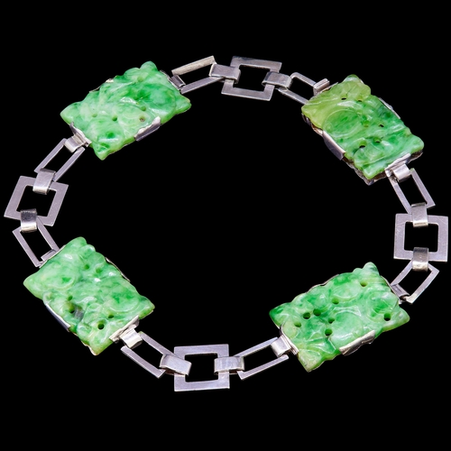 43 - JADE LINK BRACELET, set with 4 green jade plaqyes, carvied with floral decoration. L. 18 cm. 13.1 gr... 
