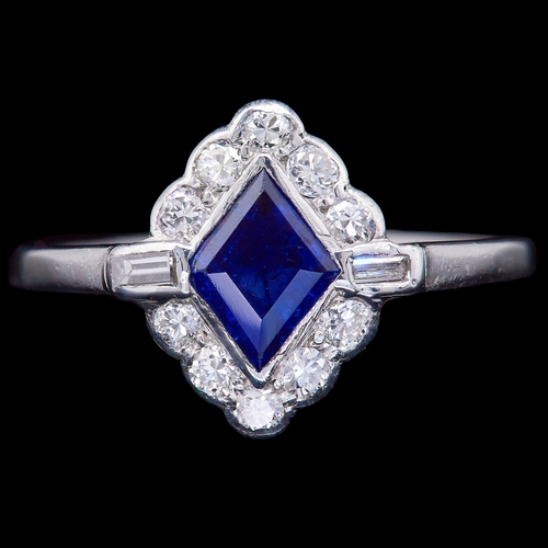 23 - SAPPHIRE AND DIAMOND CLUSTER RING, set with a central blue sapphire of approx. 0.65 ct. Flanked with... 
