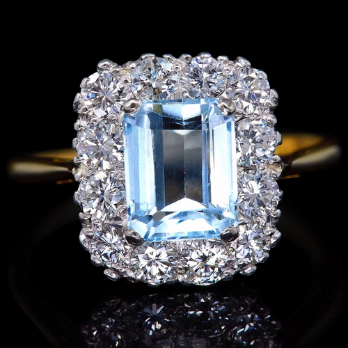 53 - AQUAMARINE AND DIAMOND CLUSTER RING, in 18 ct. gold. Set with a central aquamarine of approx. 1.57 c... 