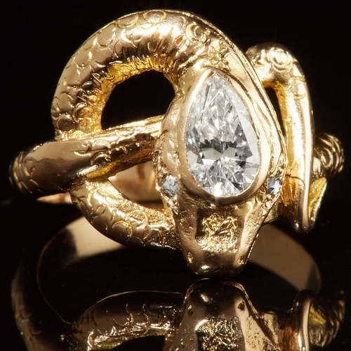 60 - DIAMOND SNAKE RING, in 18 ct. gold. Designed as a curled snake, set with a pear shaped diamond to th... 