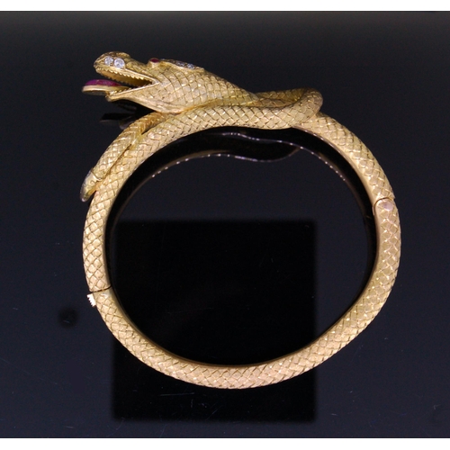 24 - A 19th CENTURY CHINEASE DRAGON BANGLE, in yellow precious metal. The tongue set with a ruby of 1.29 ... 