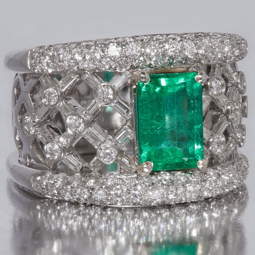 41 - IMPRESSIVE EMERALD AND DIAMOND RING, in 18 ct. white gold. Set with a central emerald of approx. 1.4... 