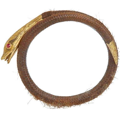 158 - ANTIQUE GARNET AND HAIR SNAKE BANGLE, the coiled sprig bangle decorated with hair. The neck, head an... 