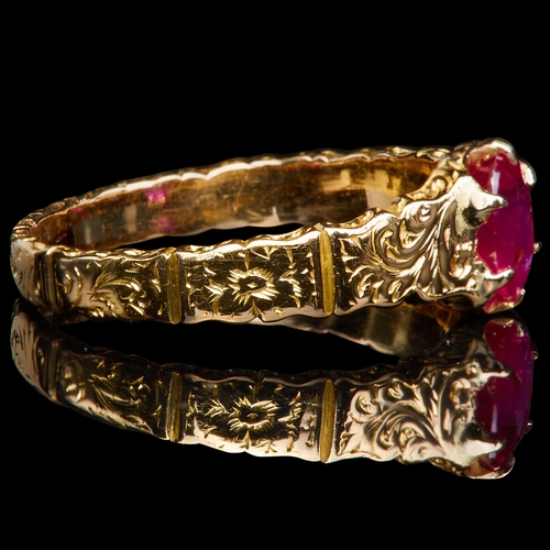 218 - RUBY RING, set with an oval ruby of approx. 0.53 ct. The shoulders and shank with engraved scrolling... 