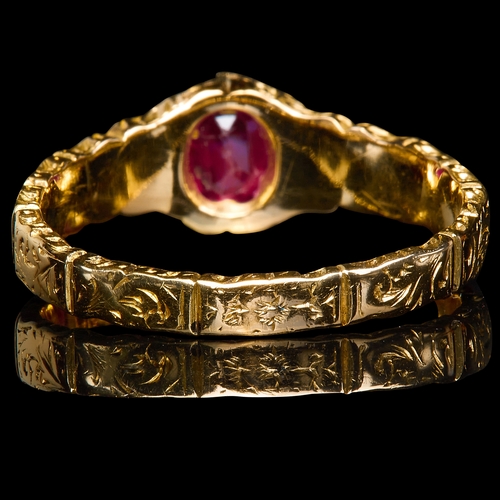 218 - RUBY RING, set with an oval ruby of approx. 0.53 ct. The shoulders and shank with engraved scrolling... 