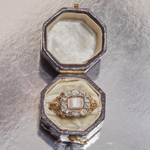 331 - VICTORIAN DIAMOND MEMORI RING, the centre set with an entwined hairwork behind a domed glass. Surrou... 