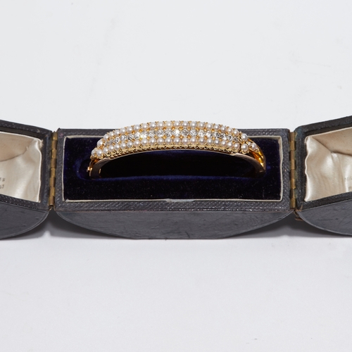 17 - IMPRESSIVE ANTIQUE DIAMOND AND PEARL HINGED BANGLE. set with a row of graduated diamonds totalling a... 