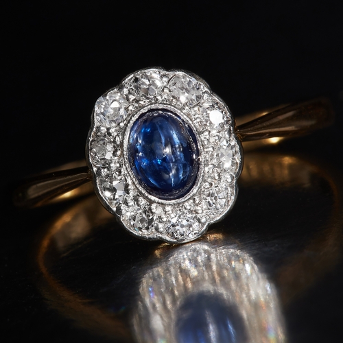 35 - SAPPHIRE AND DIAMOND CLUSTER RING, in 18 ct. gold and platinum. Set with a central cabochon cut blue... 