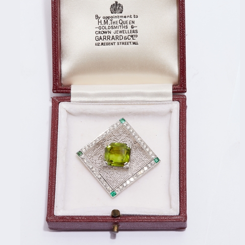 19 - PERIDOT, DIAMOND AND EMERALD BROOCH, of opework square design. Set to the center with a peridot f ap... 