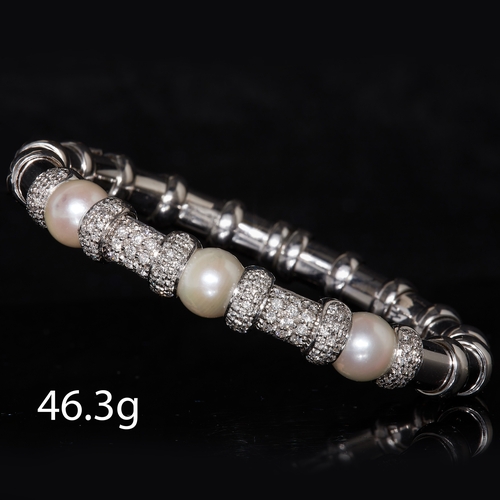 32 - DIAMOND AND PEARL SPRING BANGLE, in 18 ct. gold. The bangle with 2 wider and 6 smaller diamond set s... 