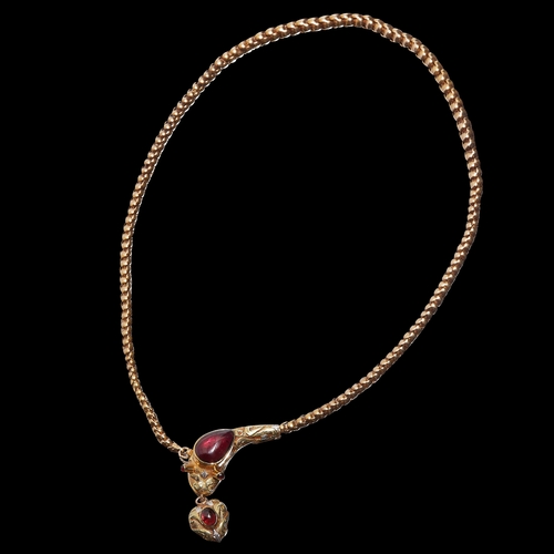 142 - VICTORIAN GARNET SET SNAKE NECKLACE. the serpent head set with a cabochon garnet. with raised caboch... 