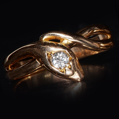 144 - EDWARDIAN DIAMOND SNAKE RING, set with a diamond to the head. Size T. 4.1 grams.
