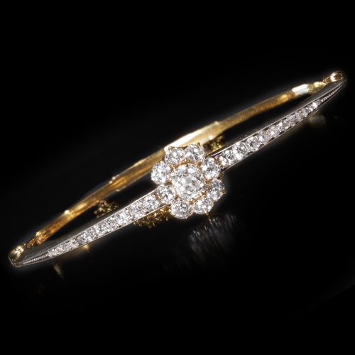 174 - DIAMOND CLUSTER HINGED GOLD BANGLE,
Diamond bright and lively, totalling approx. 1.85 ct.
Inner diam... 