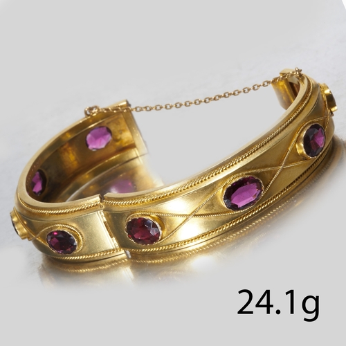 114 - ANTIQUE VICTORIAN GARNET ETERNITY HINGED BANGLE,
24.1 grams, High carat gold.
Set with 6 vibrant gar... 