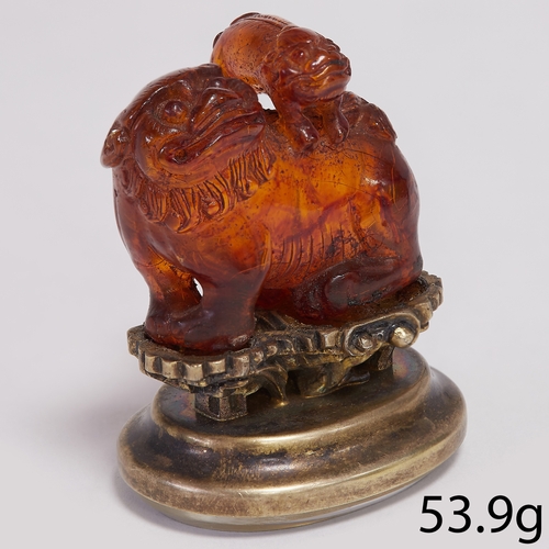 205 - CHINESE ANTIQUE CARVED AMBED FOO-DOG WITH CUB SEAL, 
53.9 grams 
The amber exhibiting a fine glow.
F... 