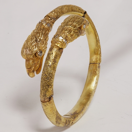 216 - FINE AND DETAILED DOUBLE EAGLE HEAD AND DIAMOND SPRUNG BANGLE,
41,5 grams, 18 ct. gold.
Detailed rel... 