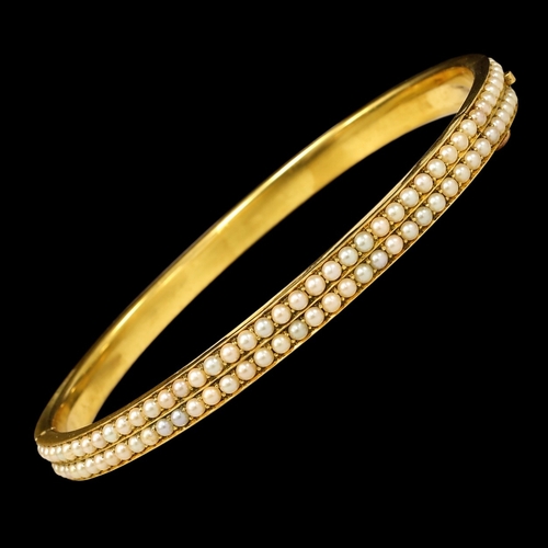 106 - VICTORIAN DOUBLE ROW PEARL HINGED BANGLE,
12.9 grams, testing high carat gold.
Pearls generally well... 