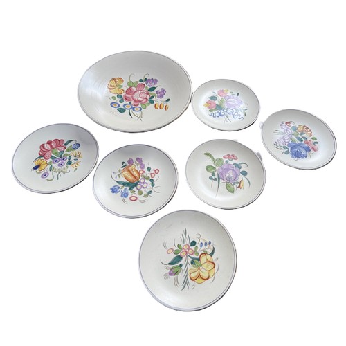 1 - A Poole Pottery set of six plates and one large serving bowl with floral motifs from the 