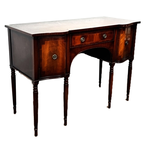 4 - A reproduction mahogany serpentine fronted sideboard, with shaped top above a series of drawers and ... 