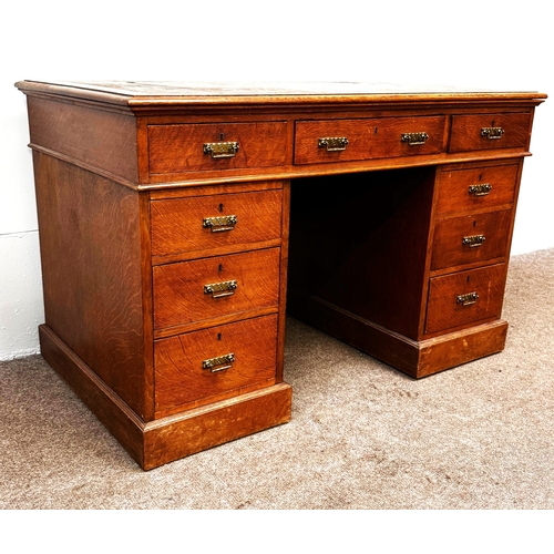 22 - A late Victorian oak pedestal desk, circa 1900,with leathered top, and arrangement of nine drawers; ... 