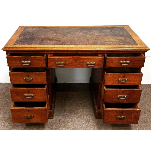 22 - A late Victorian oak pedestal desk, circa 1900,with leathered top, and arrangement of nine drawers; ... 