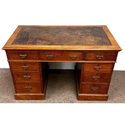 22 - A late Victorian oak pedestal desk, circa 1900,with leathered top, and arrangement of nine drawers; ... 