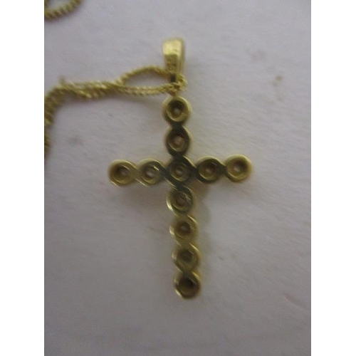 14 - An 18ct gold cross pendant set with eleven diamonds on a fine chain