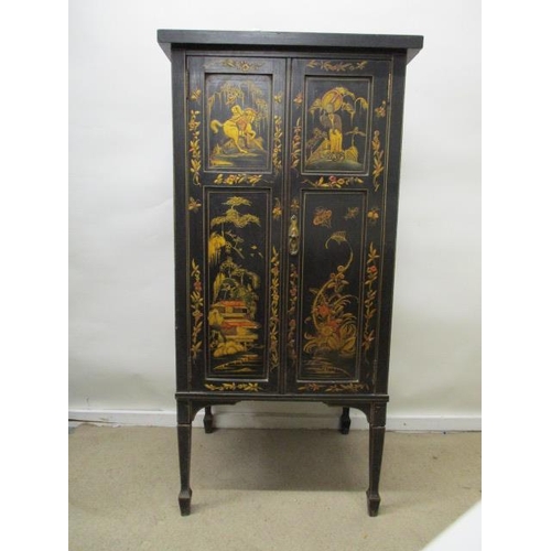 202 - An early 20th century chinoiserie decorated and black painted music cabinet with twin panelled doors... 