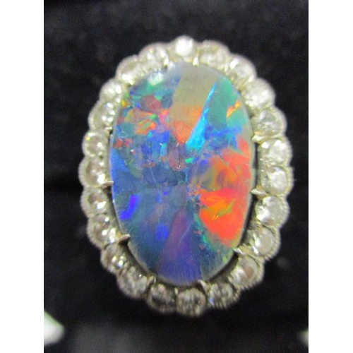 57 - An 18ct white gold ring set with twenty three diamonds around an opal doublet, opal approximately 17... 