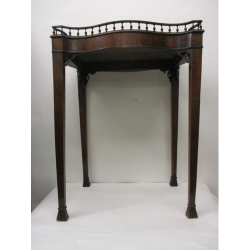 244 - A 19th century mahogany, serpentine outlined silver table having a spindle, galleried top, raised on... 