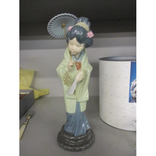 104 - A Lladro figure of a Geisha girl with a parasol