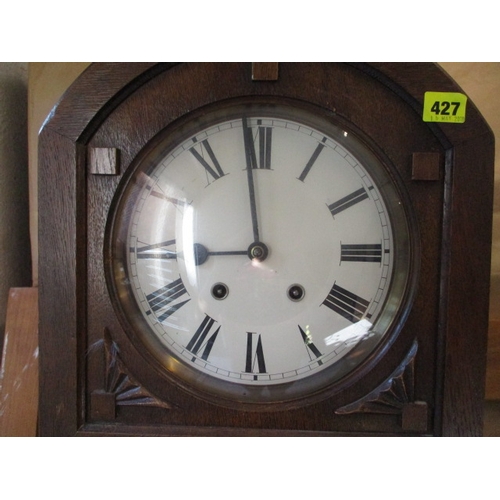 427 - An early 20th century oak arched top grandmother clock with visible pendulum door