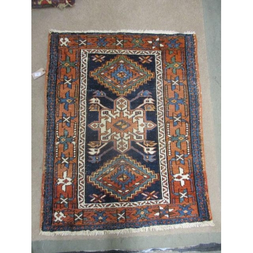 128 - A Persian rug with a central medallion and two stepped diamonds on a dark blue ground, 46