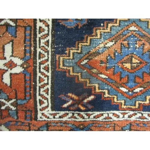 128 - A Persian rug with a central medallion and two stepped diamonds on a dark blue ground, 46