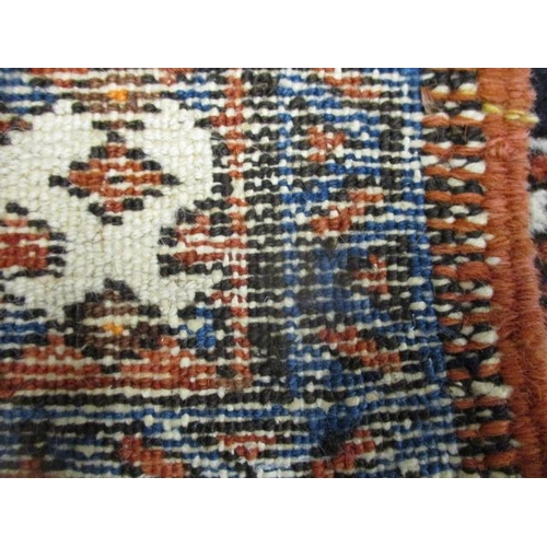 128 - A Persian rug with a central medallion and two stepped diamonds on a dark blue ground, 46