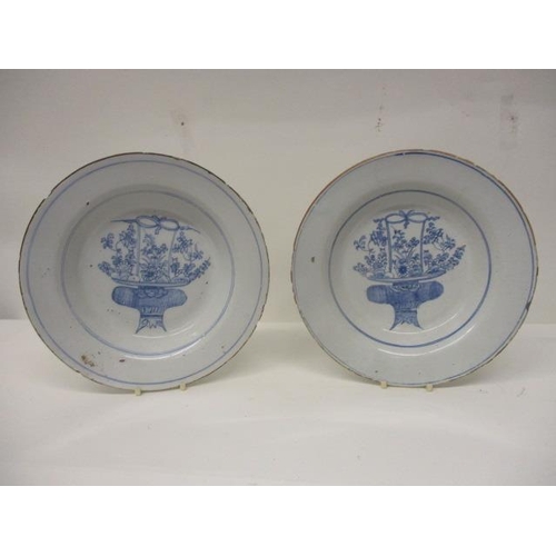 220 - A pair of mid 18th century English Delft dishes, each decorated in blue and white with a basket of f... 