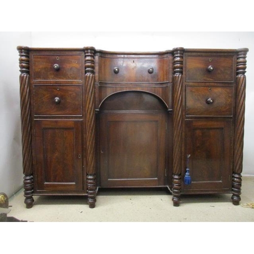 275 - An early 19th century mahogany sideboard having an in-curved front with a drawer and a panelled door... 