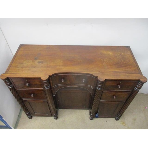 275 - An early 19th century mahogany sideboard having an in-curved front with a drawer and a panelled door... 