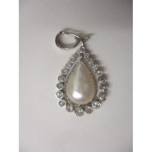 242 - A platinum pendant with a suspended teardrop peal and set with twenty diamonds, approximately 1ct