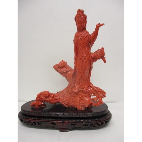 102 - A 20th century Chinese carved, red coloured coral figure of a Goddess standing on a branch, by a bir...