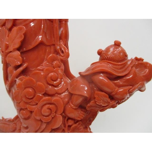 102 - A 20th century Chinese carved, red coloured coral figure of a Goddess standing on a branch, by a bir... 