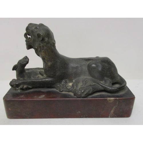 296 - An early 19th century Indian cast bronze model of a lion with a fawn, on a red marble base, 3 3/4